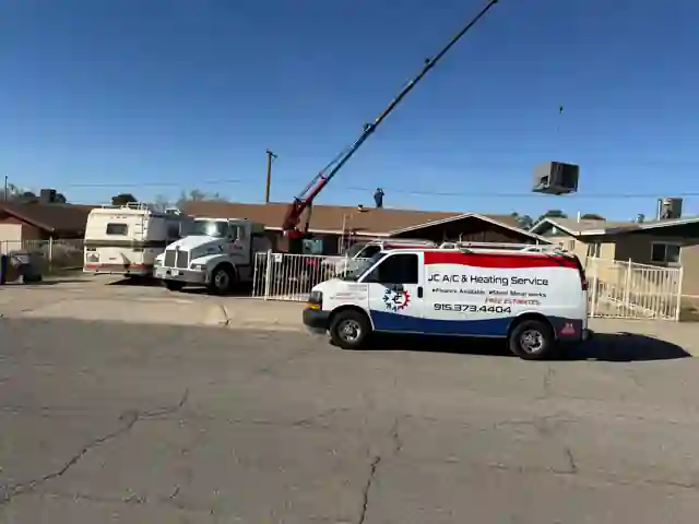 JC AC & Heating Service rooftop HVAC installation with a crane and service van